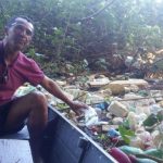 Ademar, morador do Itaguá, no barco fazendo a limpeza do rio