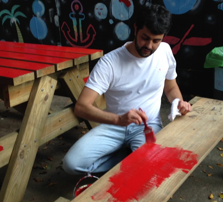 homem pintando banco durante ação do cidade ativa